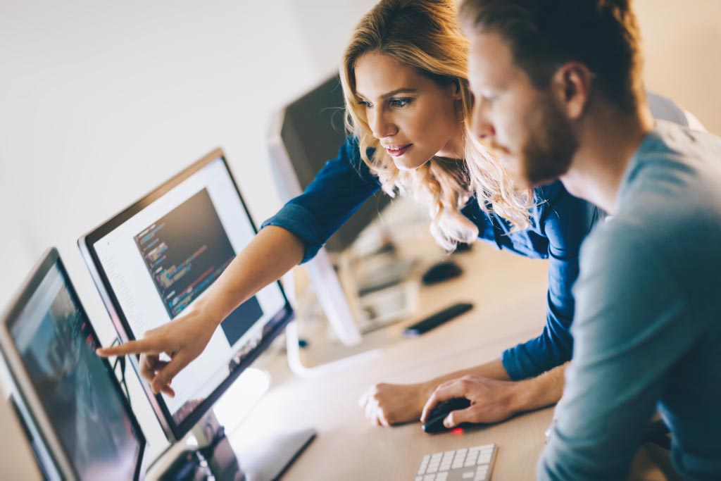 Woman pointing to computer monitor screen.