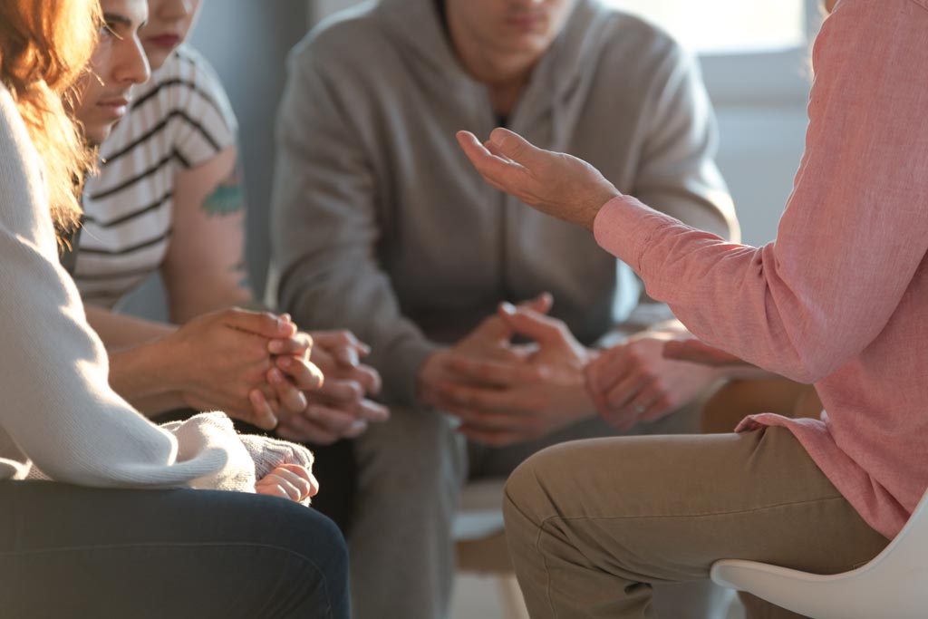 Group of people sitting in a circle and having a discussion.