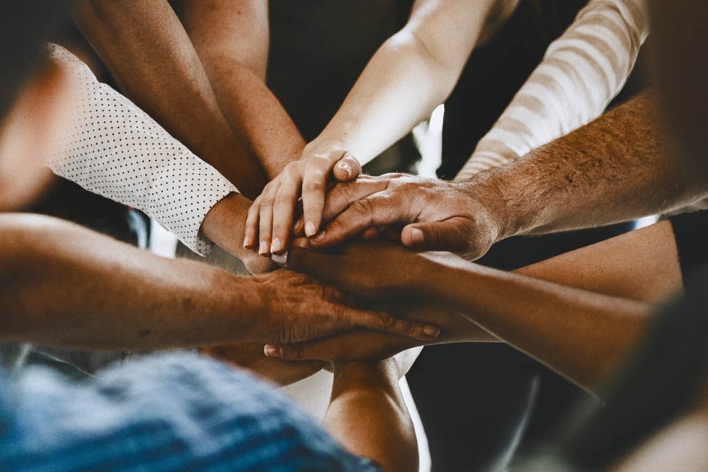 Stack of hands symbolizing teamwork and unity.